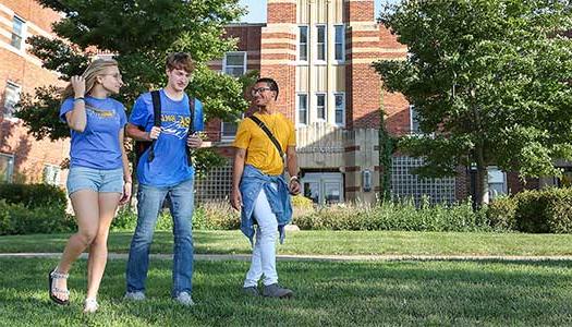 3 学生 walking in front of Men's Hall